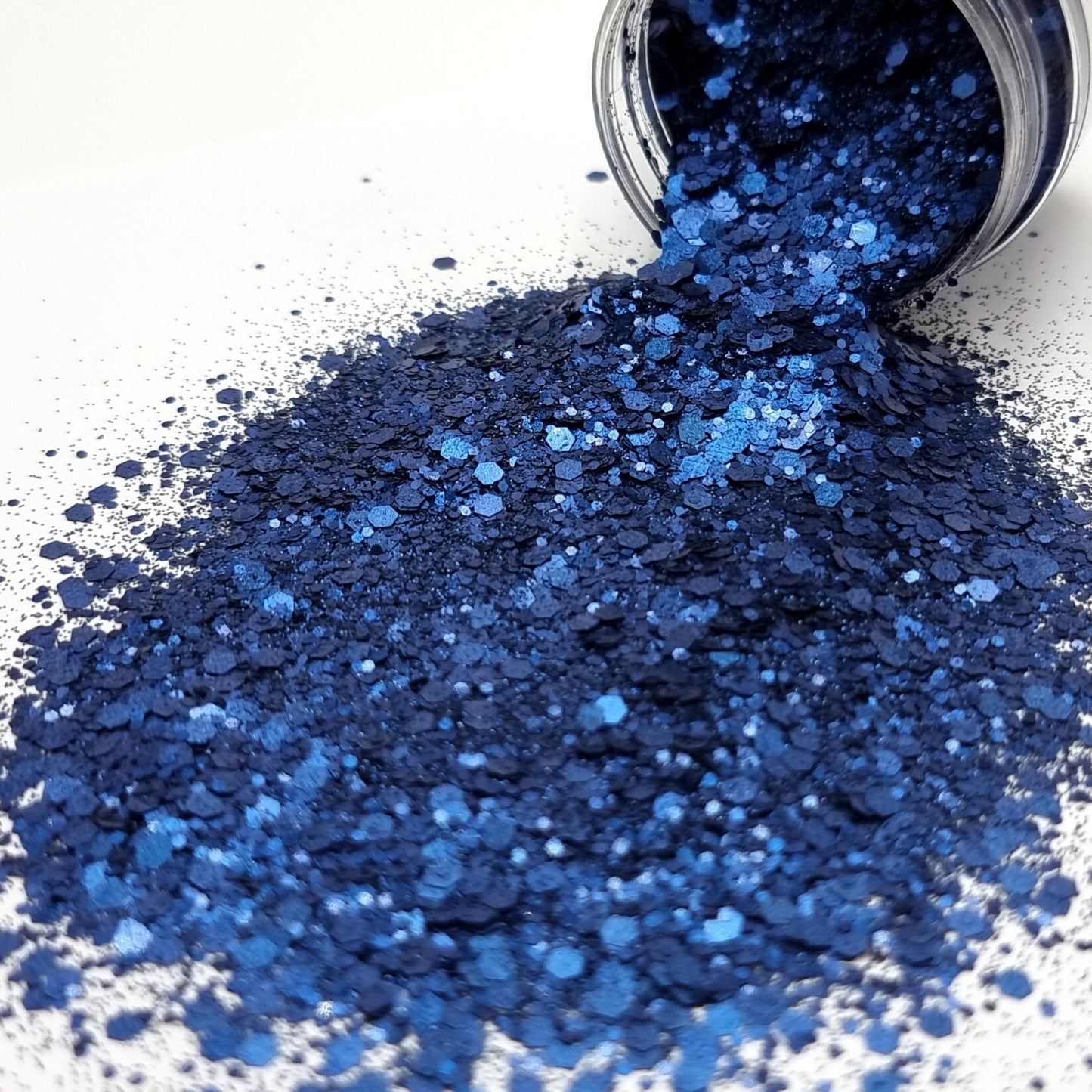 Entice is a dark blue mixed size hex chunky glitter. 