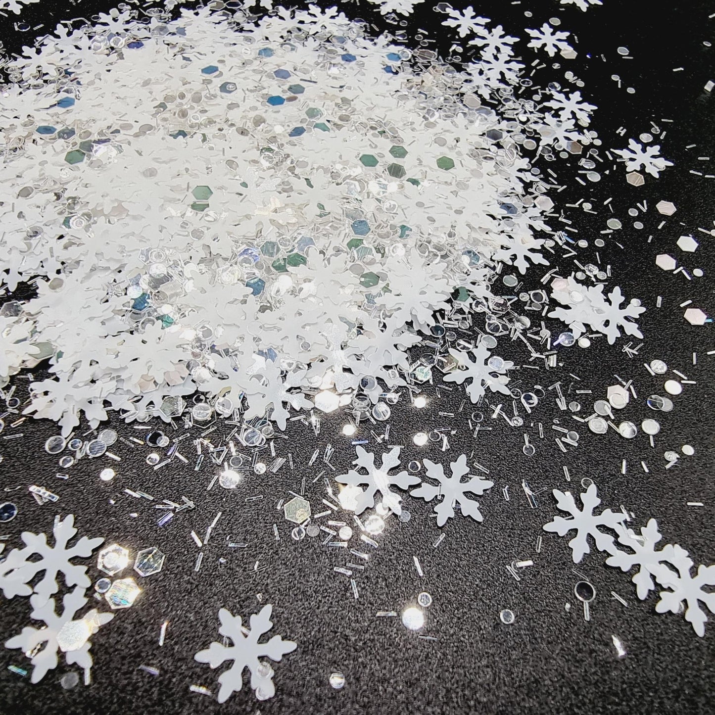 White Christmas is a white and silver mix consisting of white snow flakes, sprinkles, circles and hex shapes.